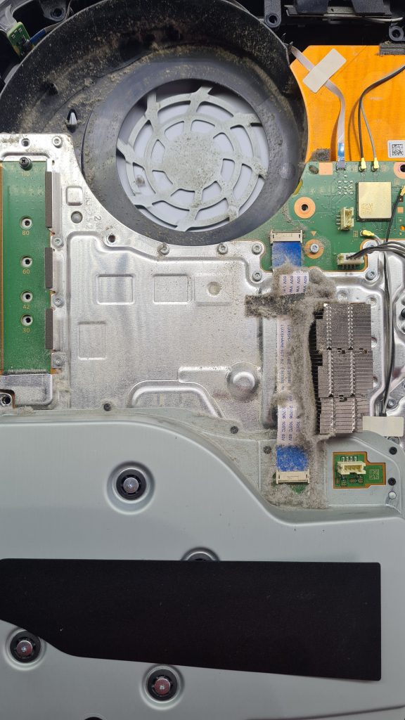 PS5 abierta con disipador lleno de polvo y suciedad – Causa común de sobrecalentamiento en GameSystems Leganés